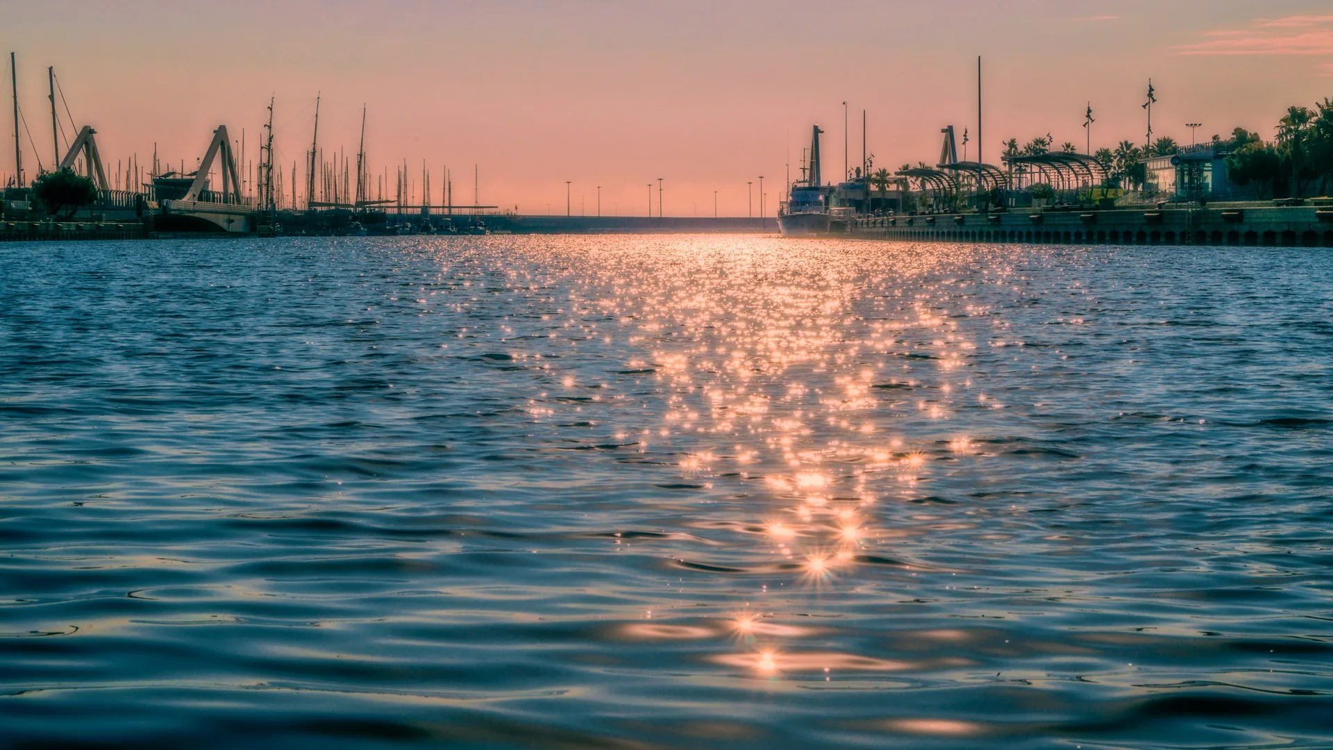 Le port de Valence au coucher du soleil, mâts et grues au bord de l'eau dans le quartier du Grau