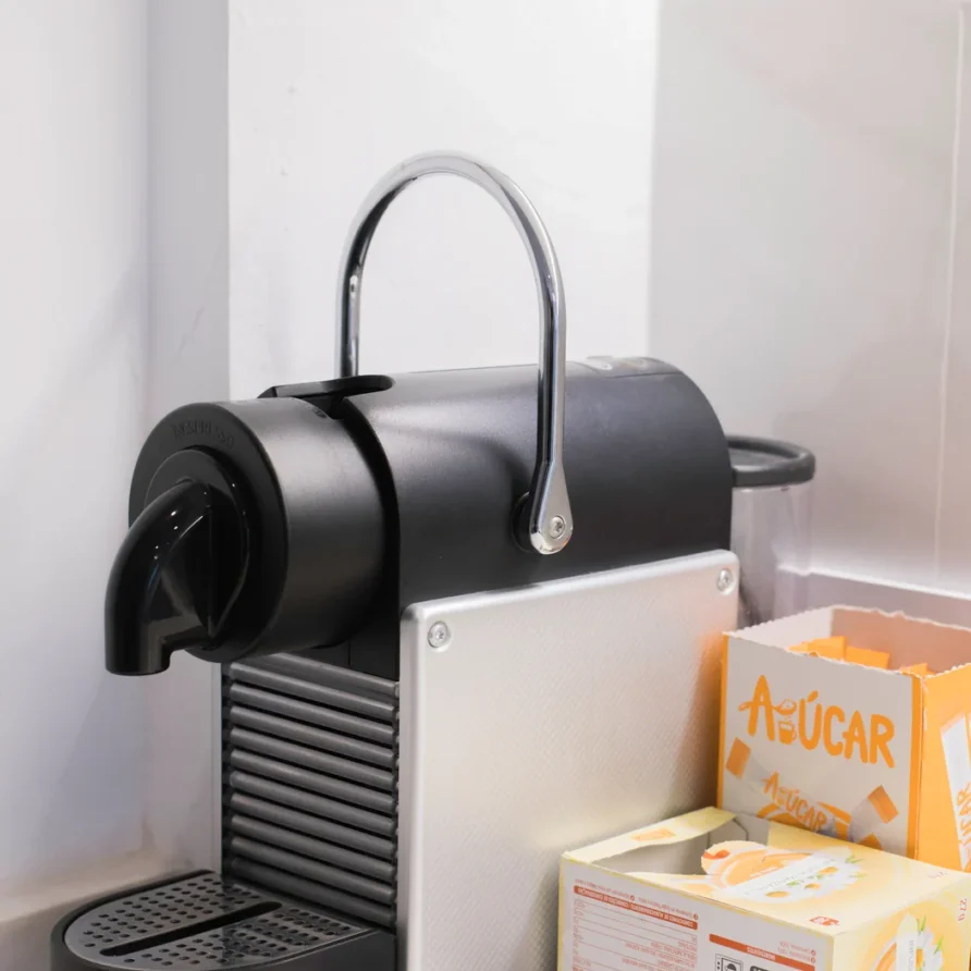 Nespresso Pixie coffee machine with a box of sugar packets