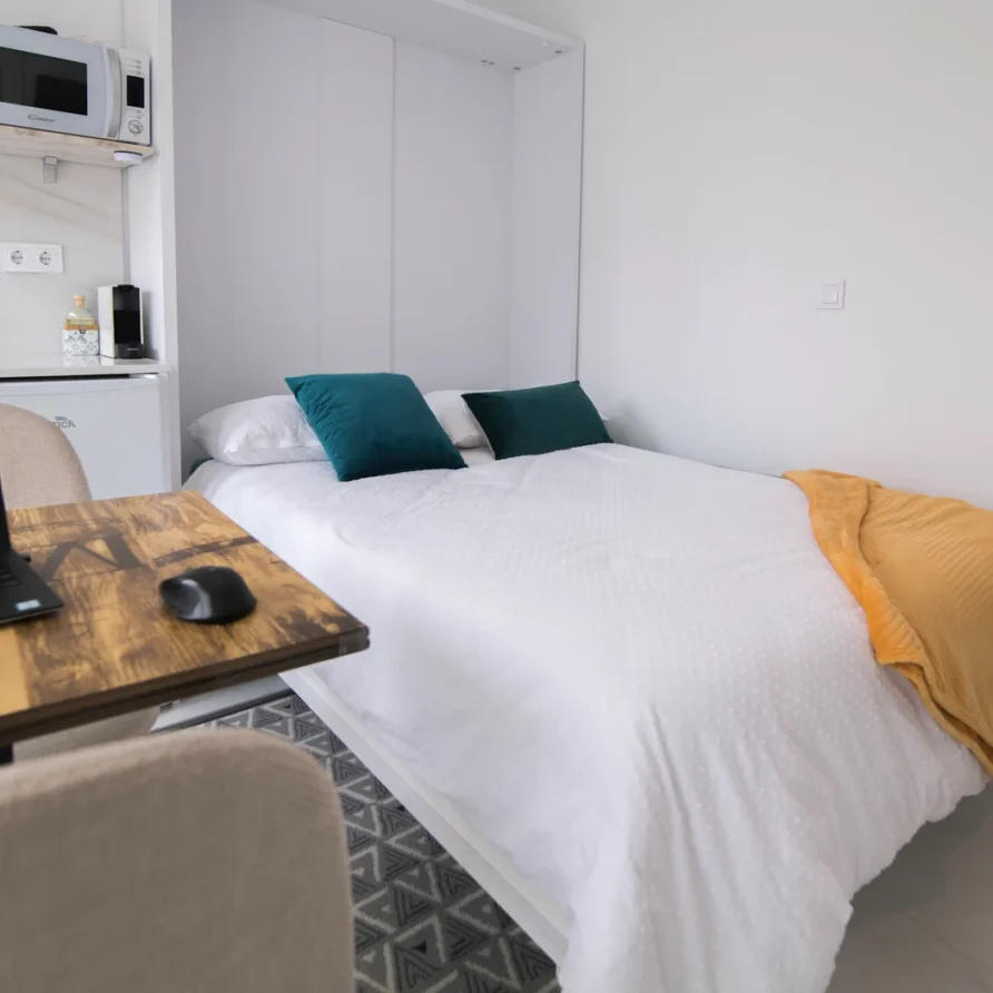Neat bed with teal pillows in modern room