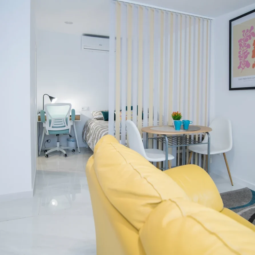 Bright modern studio with yellow sofa and desk