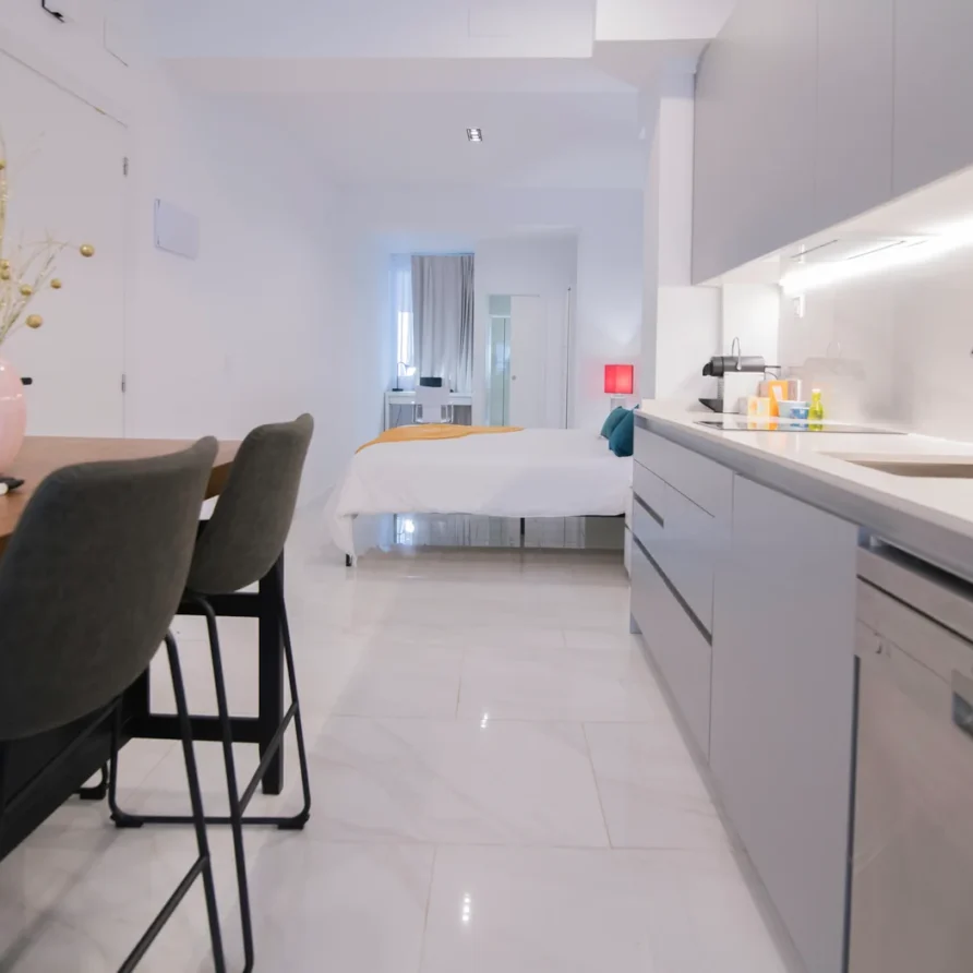Modern studio apartment with a bed, kitchenette, and dining area