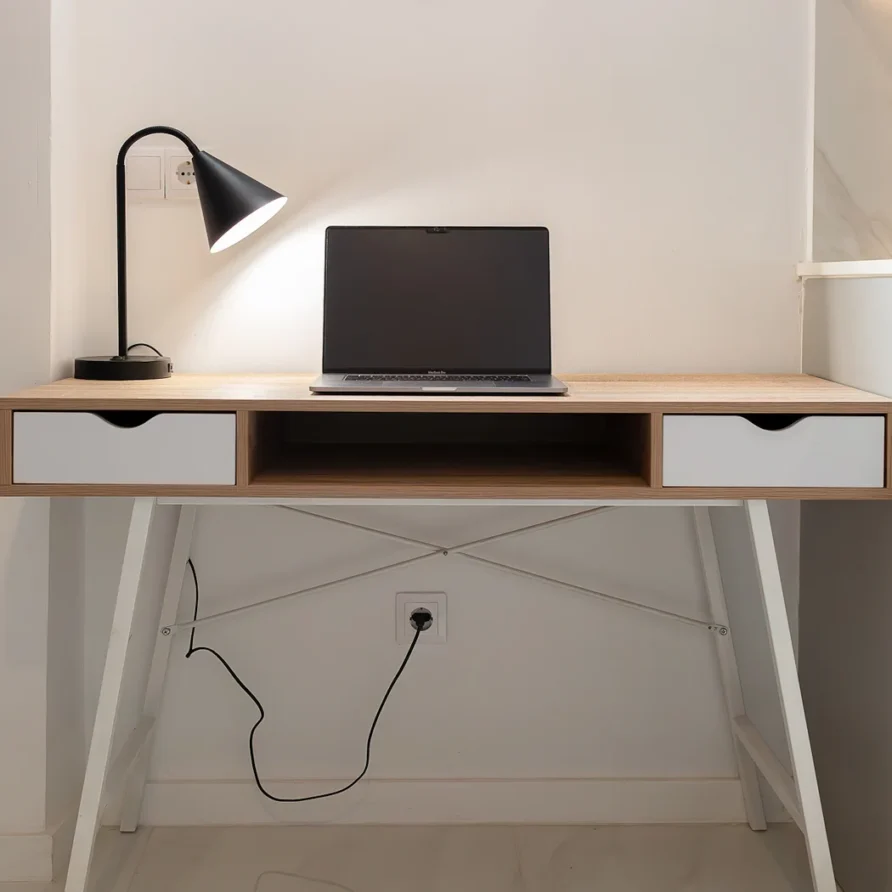 Light oak and white desk with laptop and black lamp