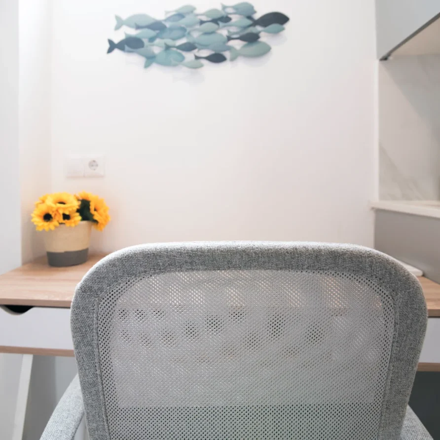 Bright workspace with gray chair and sunflowers