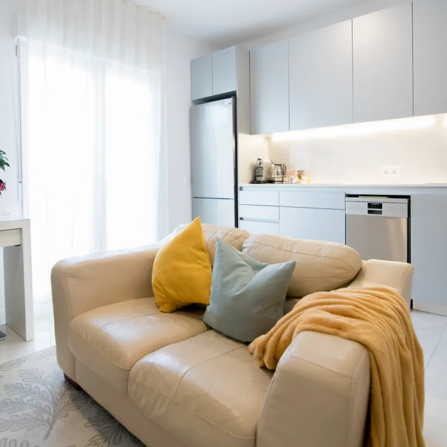 Modern living room and kitchen with a beige sofa