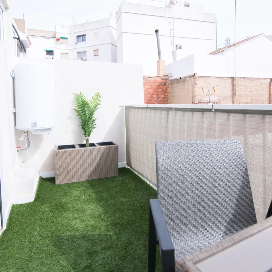 A small outdoor patio with artificial grass