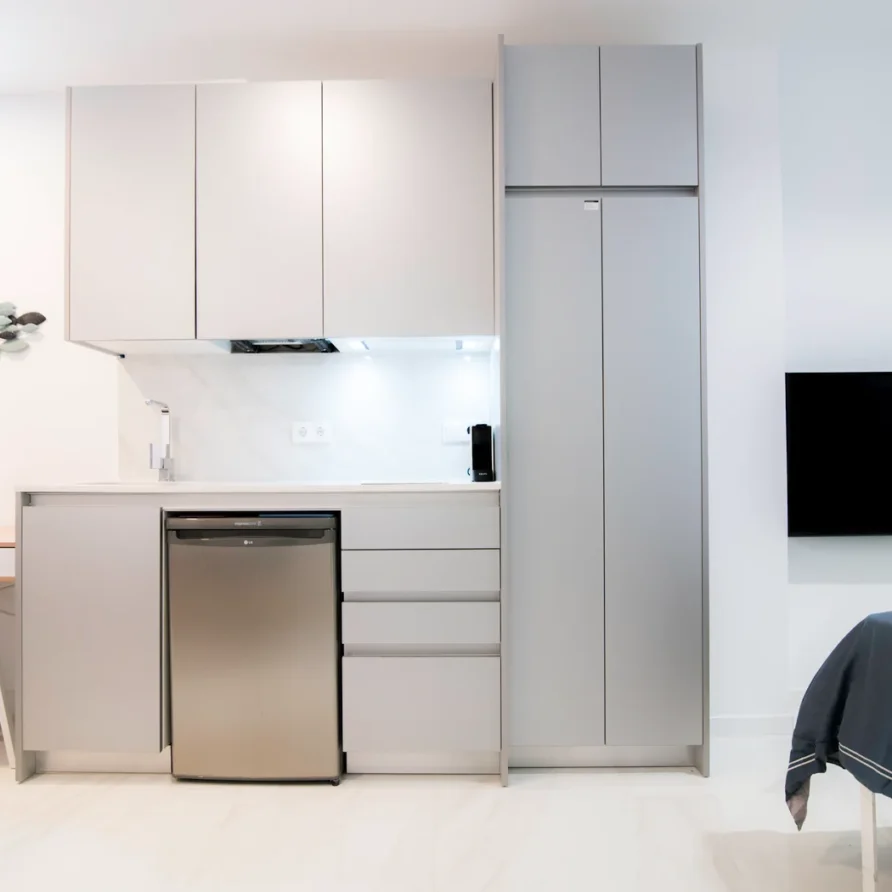 Modern kitchen area with light grey cabinets