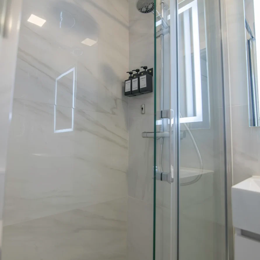 Modern bathroom with a walk-in shower and marble-patterned walls