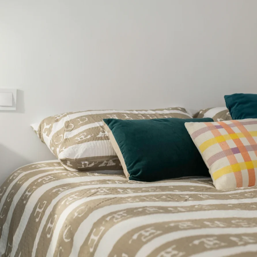 A close-up of a bed with striped bedding and pillows